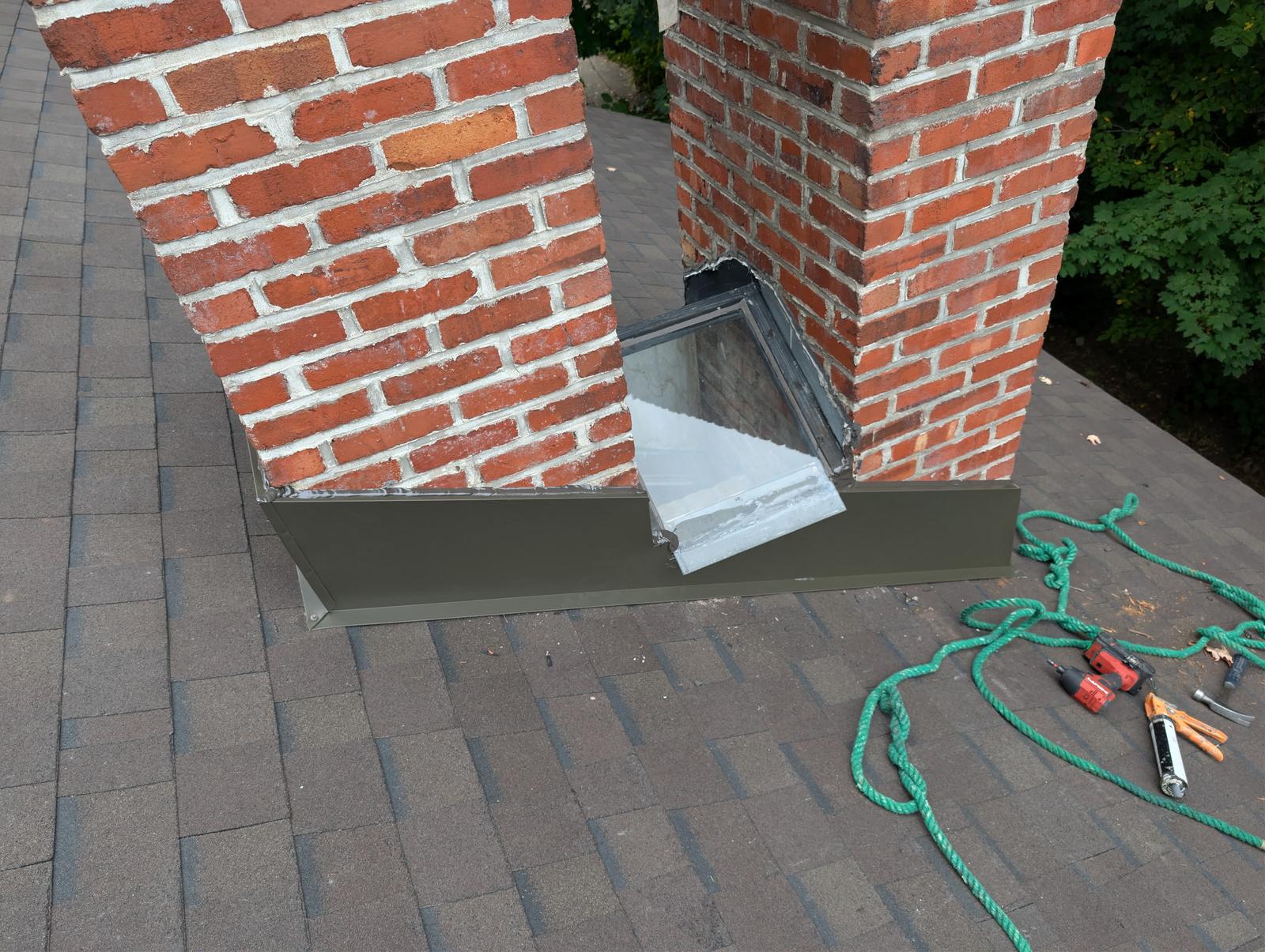 Nouveau solin métallique installé à la base de deux cheminées en brique à Westmount