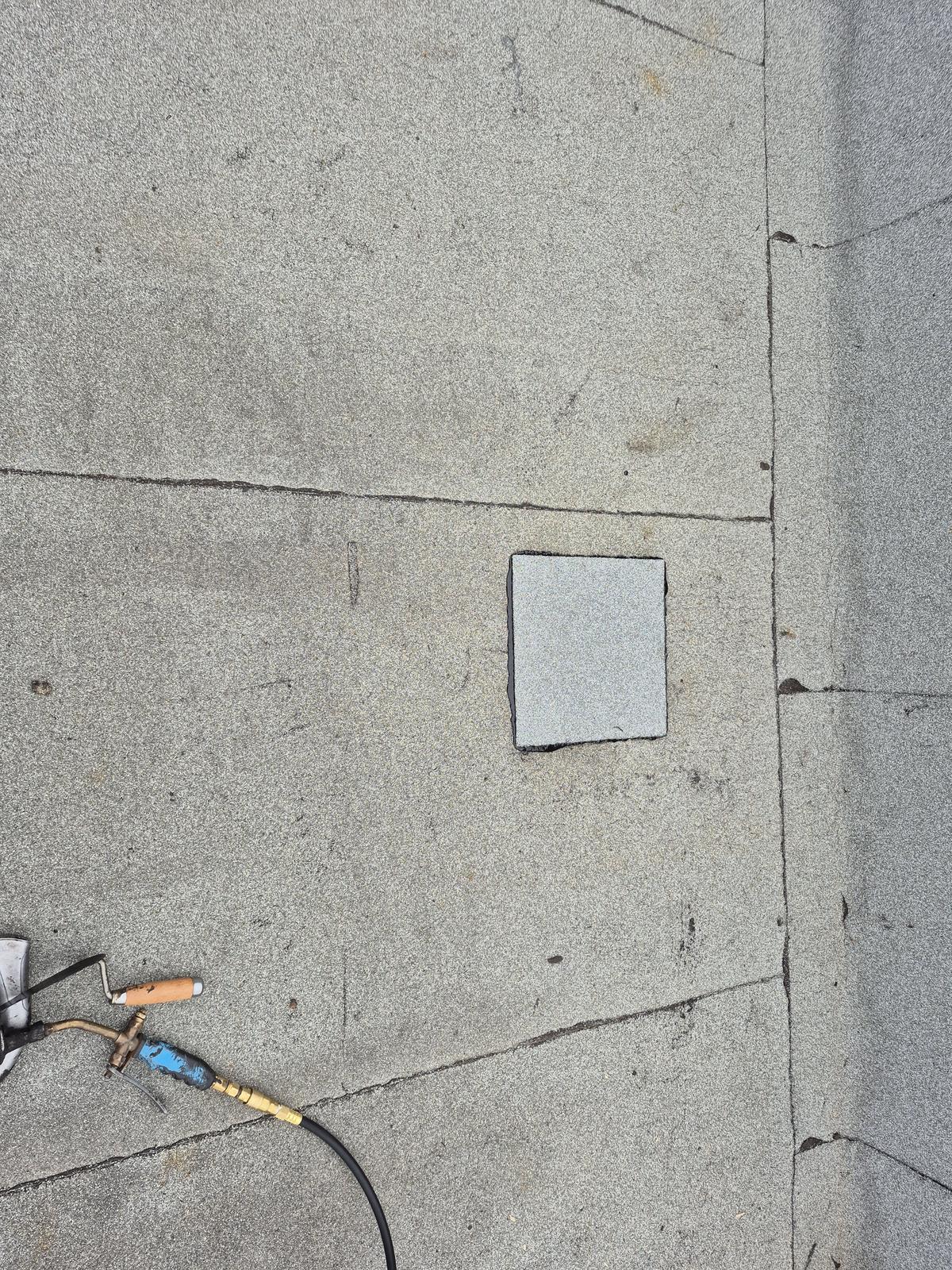 Pièce de membrane élastomère posée sur la surface d'un toit plat réparé à Laval